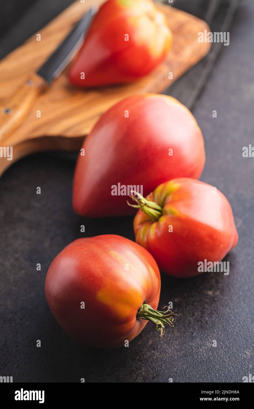 Bull heart tomatoes on a black table. Stock Photo