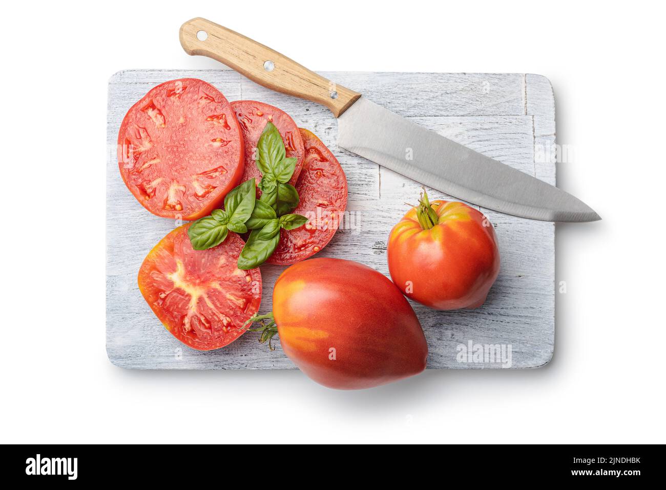 Sliced bull heart tomatoes on cutting board isolated on a white background. Stock Photo