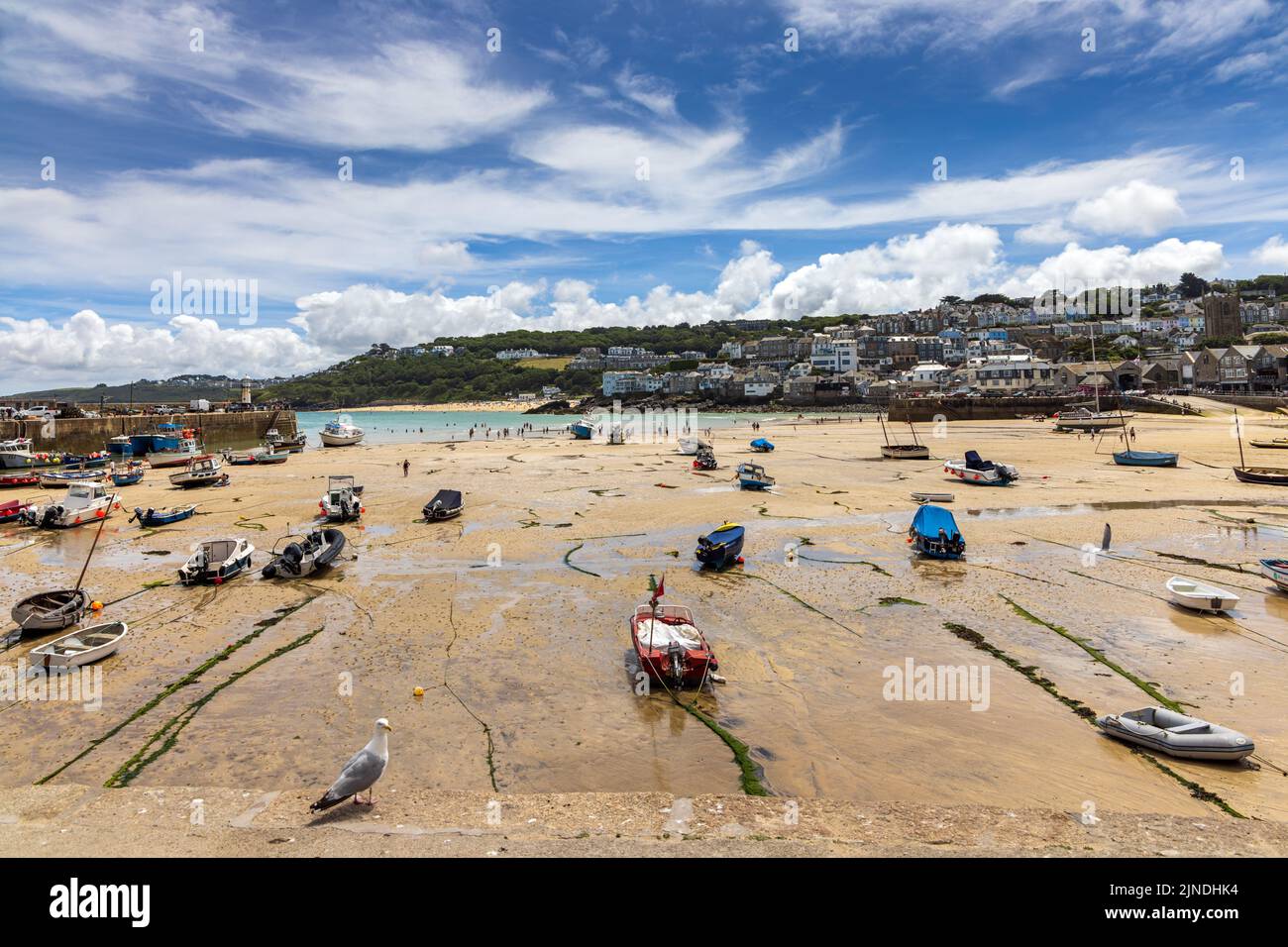 Beached boats at low tide in the sandy harbour of St Ives in Cornwall. Stock Photo
