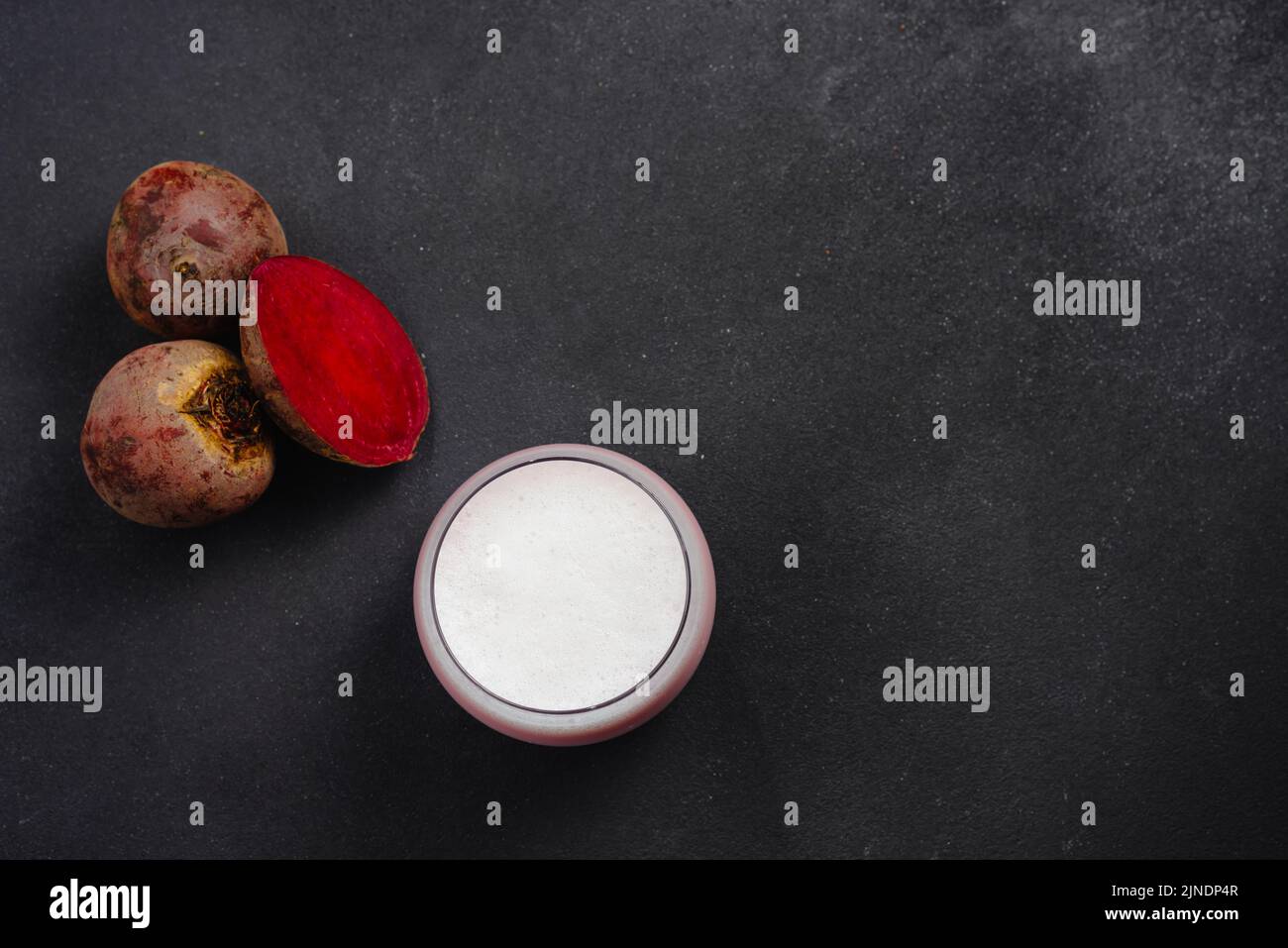 A cup of hot beet coffee latte on a black background. A trendy, healthy drink. An alternative to