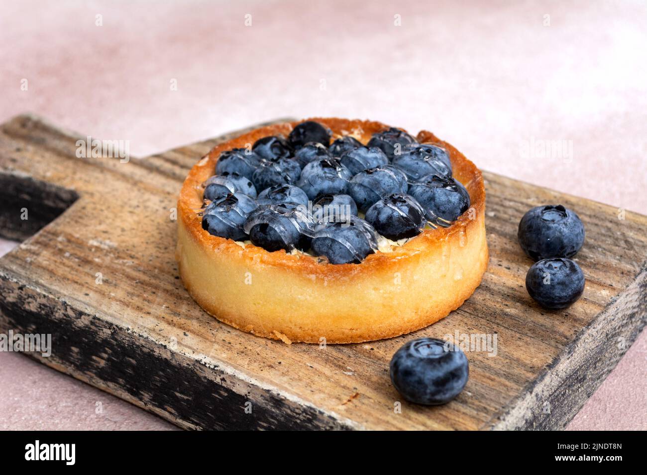 Blueberry pie on a wooden board. Blueberry tart. Berry dessert on a wooden background. Stock Photo