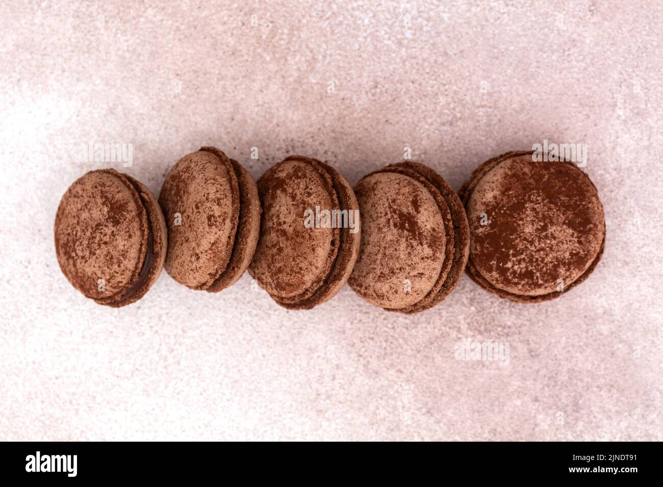 Chocolate french macaroons on a light background. Flat lay top view Stock Photo