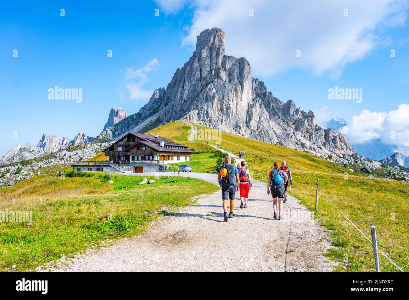 Group of hikers walks towards mountains Stock Photo