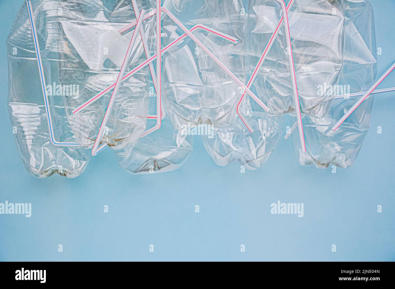 Plastic waste, plastic bottles and straws on a blue background. The concept of waste disposal and ecology. Zero waste. Pollution, environmental protec Stock Photo
