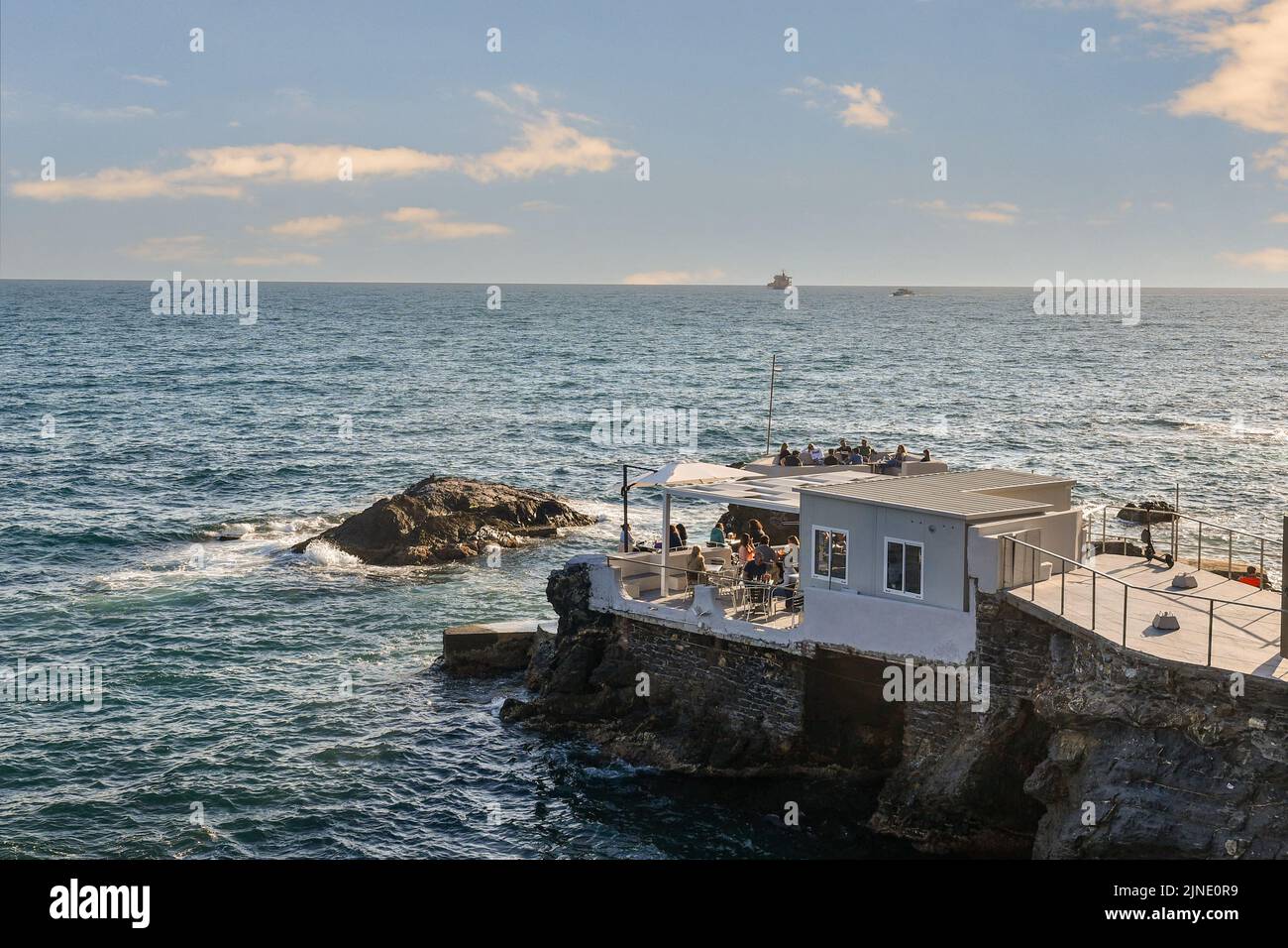 Elevated view of a beach cafè on the cliff by the sea with people having aperitifs at sunset, Nervi, Genoa, Liguria, Italy Stock Photo