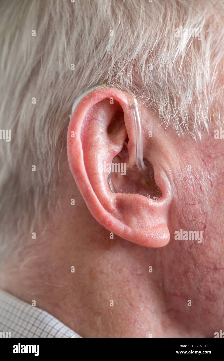 Old man with modern hearing aid in his ear Stock Photo