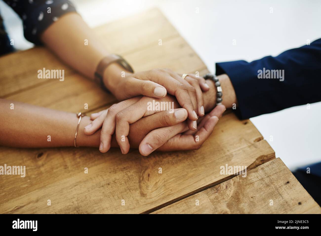 Hands holding abuse victim in a therapy session for support and comfort