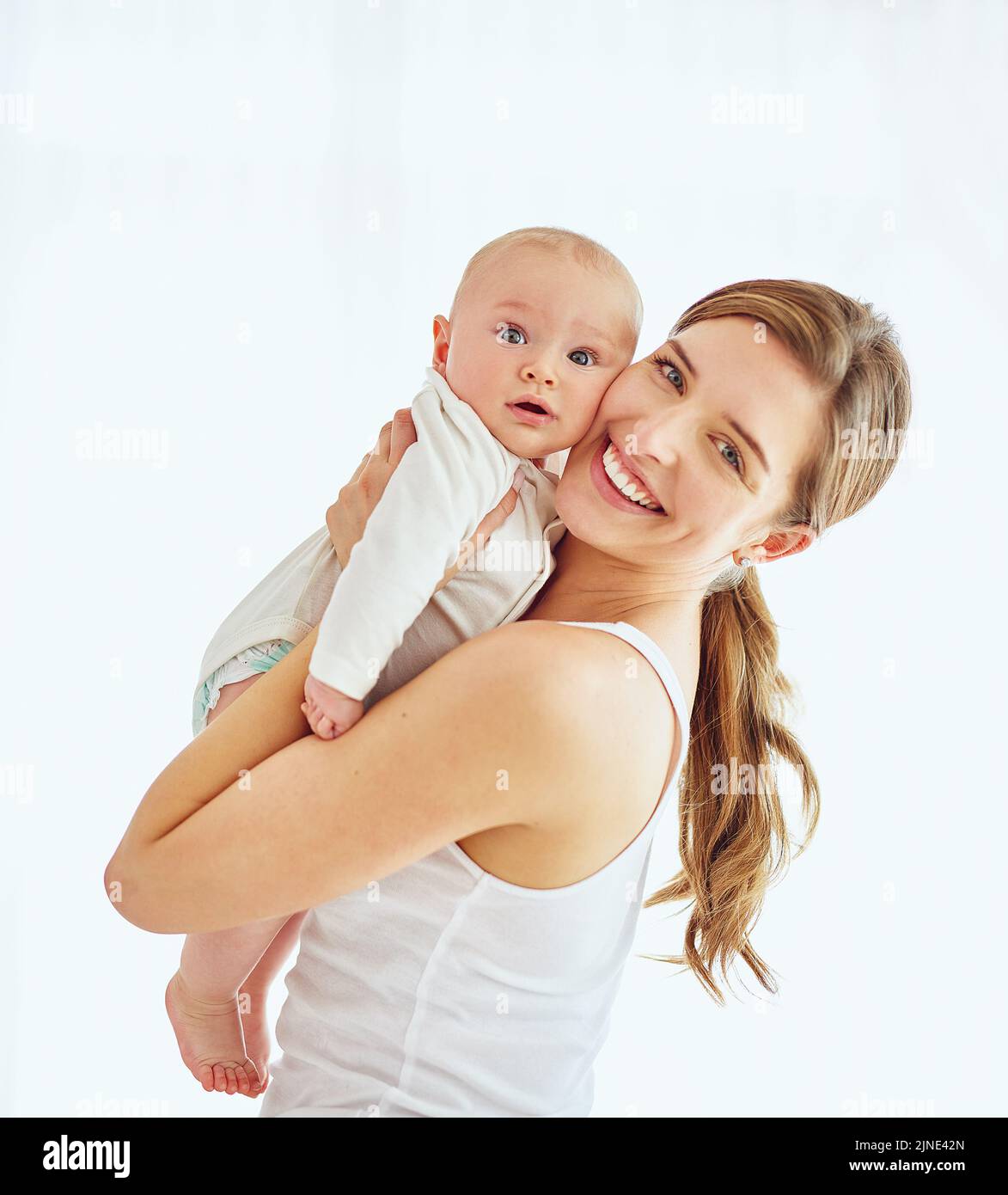 Portrait of a happy young mother hugging her cute baby boy at home, bonding and enjoying parenthood. Single parent being playful and affectionate Stock Photo