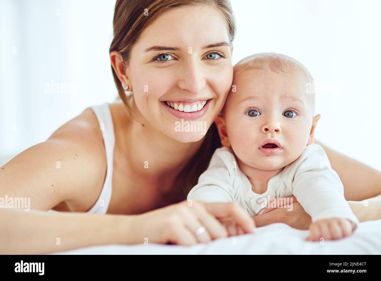 Portrait of happy and loving mother bonding with her cute baby boy at home while enjoying parenthood. Single parent being playful and affectionate Stock Photo