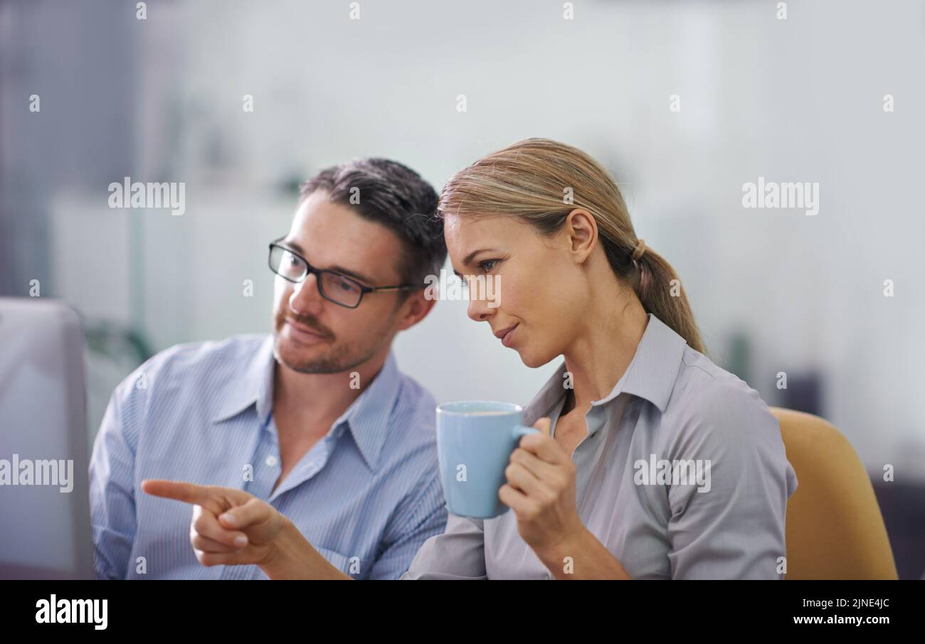 Professional business people working together on a computer, doing quality assurance and looking at information. A corporate man and woman thinking of Stock Photo