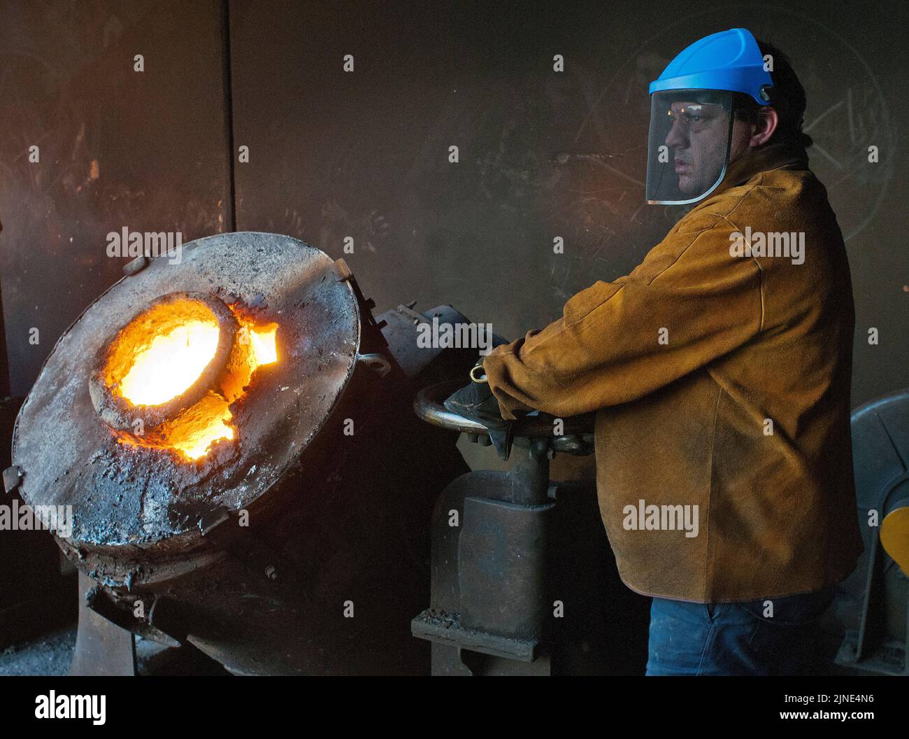 Foundry worker at the furnace in a small family foundry in Perth, Western Australia Stock Photo