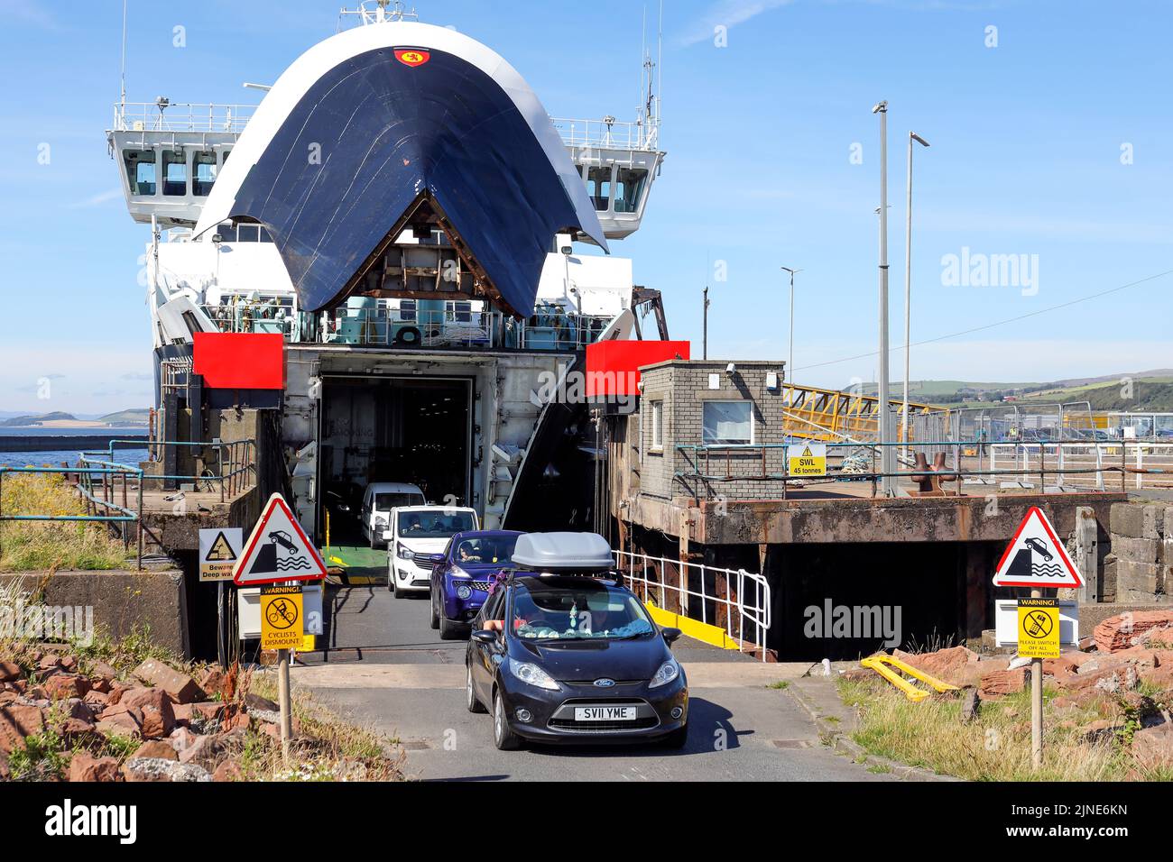 Caledonian MacBrayne ferry, Caledonian Isles, sailing from Isle of Arran, across the Firth of Clyde, berthed at Ardrossan and vehicles driving off. Ay Stock Photo