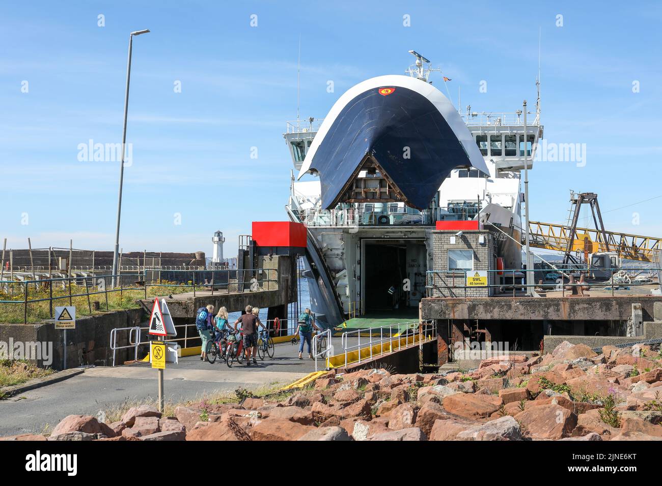 Caledonian MacBrayne ferry, Caledonian Isles, sailing from Isle of Arran, across the Firth of Clyde, berthed at Ardrossan and cyclists boarding via th Stock Photo
