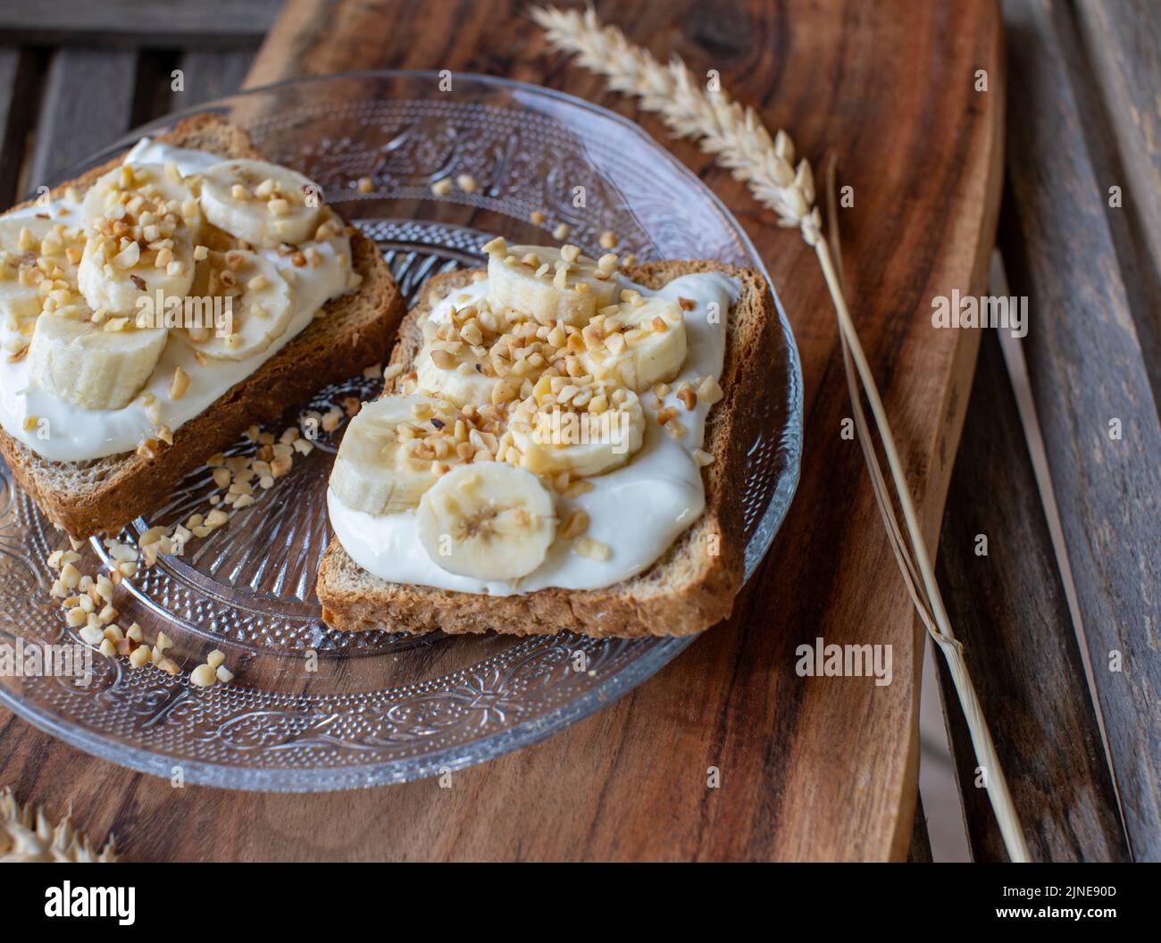 Breakfast with bananas, toast, quark and roasted nuts Stock Photo