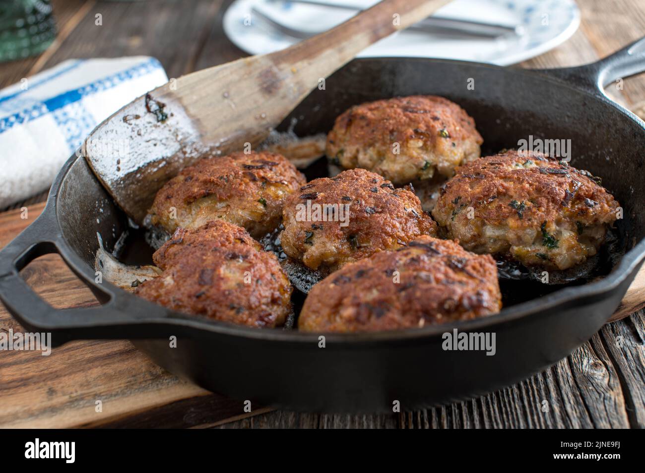 Danish Pork meatballs, 'Frikadeller'  in a frying pan on wooden table Stock Photo