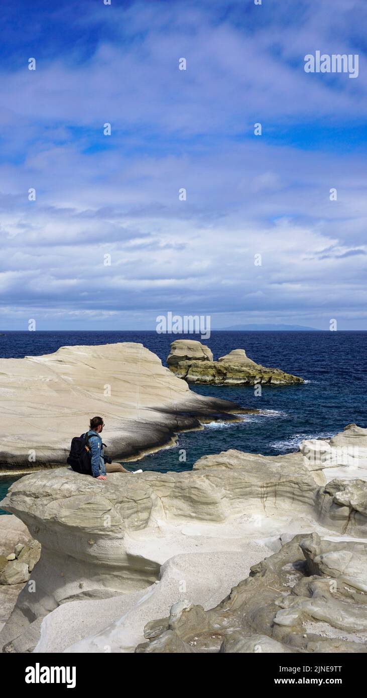 Man sitting on rock from behind hi-res stock photography and images - Alamy