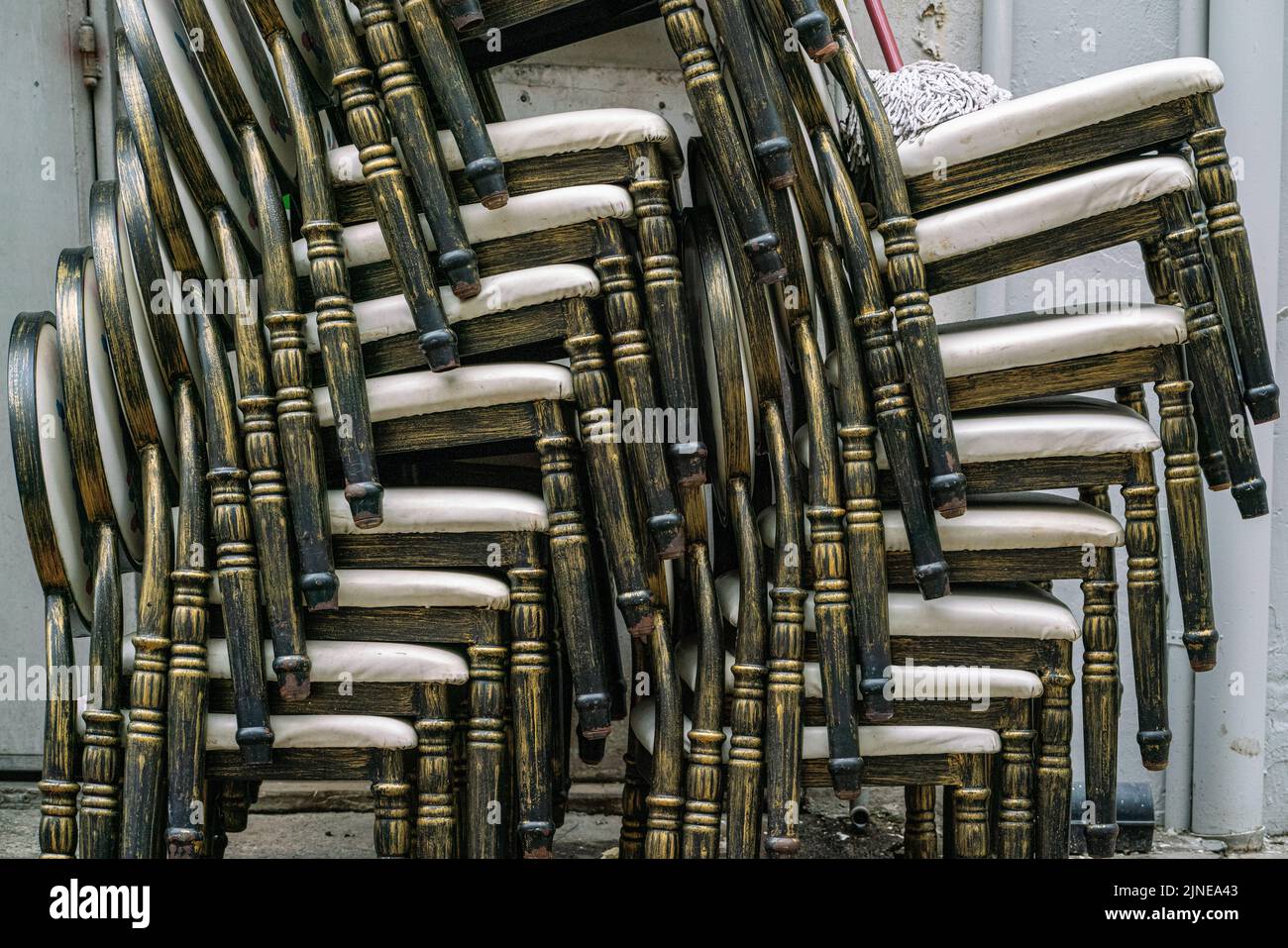 Stacked chairs are hidden in the back alley of Boat Quay, Singapore