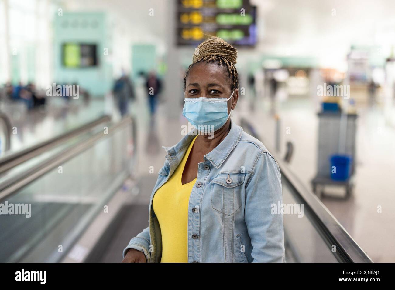 African senior passenger waiting inside departure terminal at airport