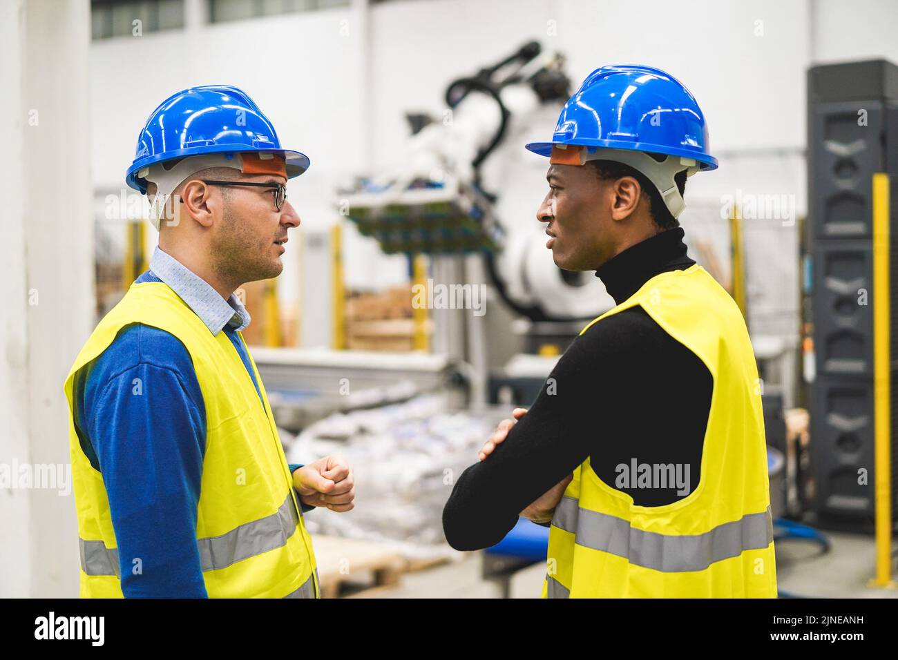 Multiethnic engineers working inside robotic factory - Focus on right man face Stock Photo