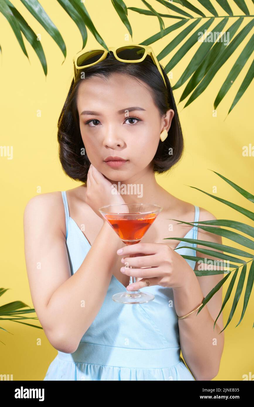 Lovely Vietnamese young woman with glass of cocktail Stock Photo