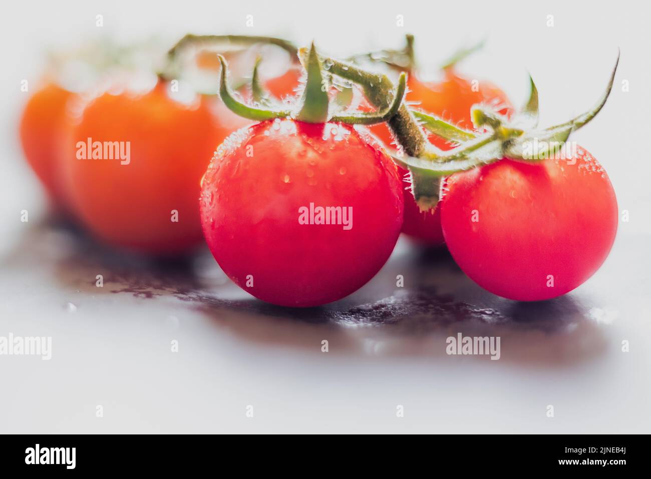 Red tomato fruits Solanum lycopersicum- (red cherry) on white background. Stock Photo