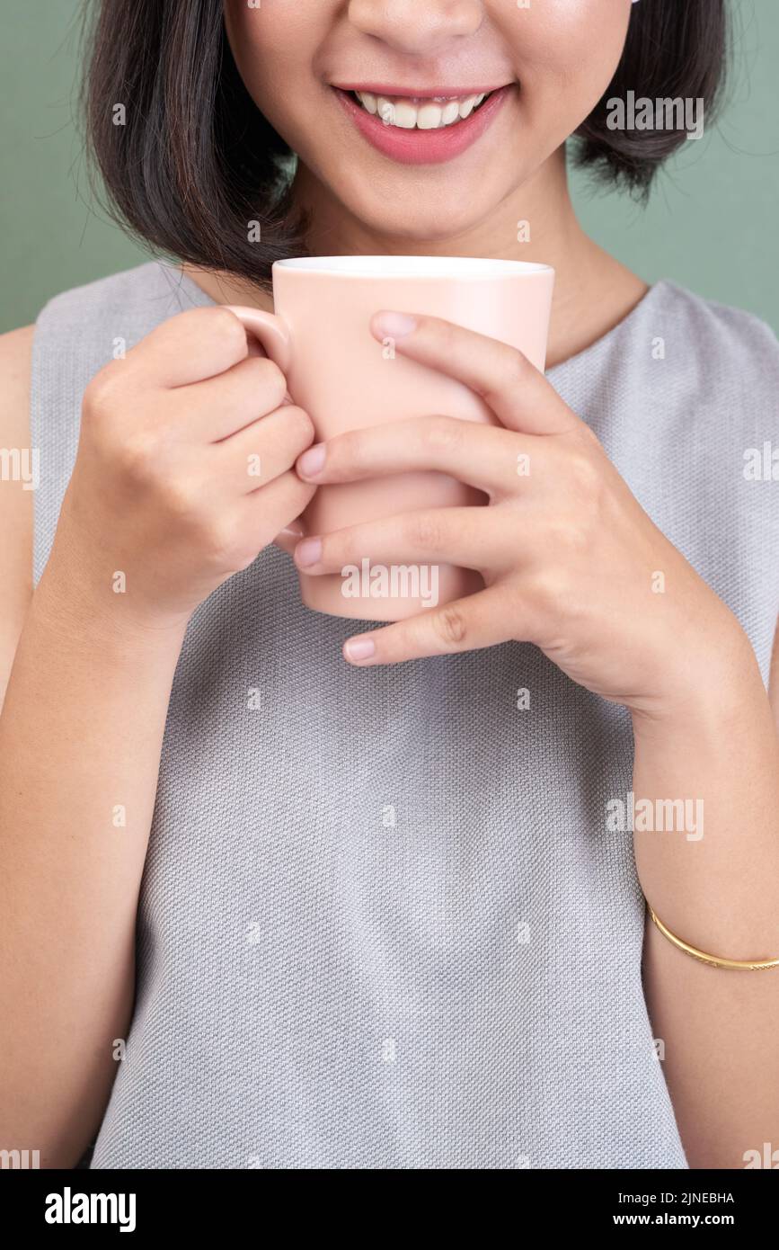Cropped image of smiling woman having big mug of coffee Stock Photo