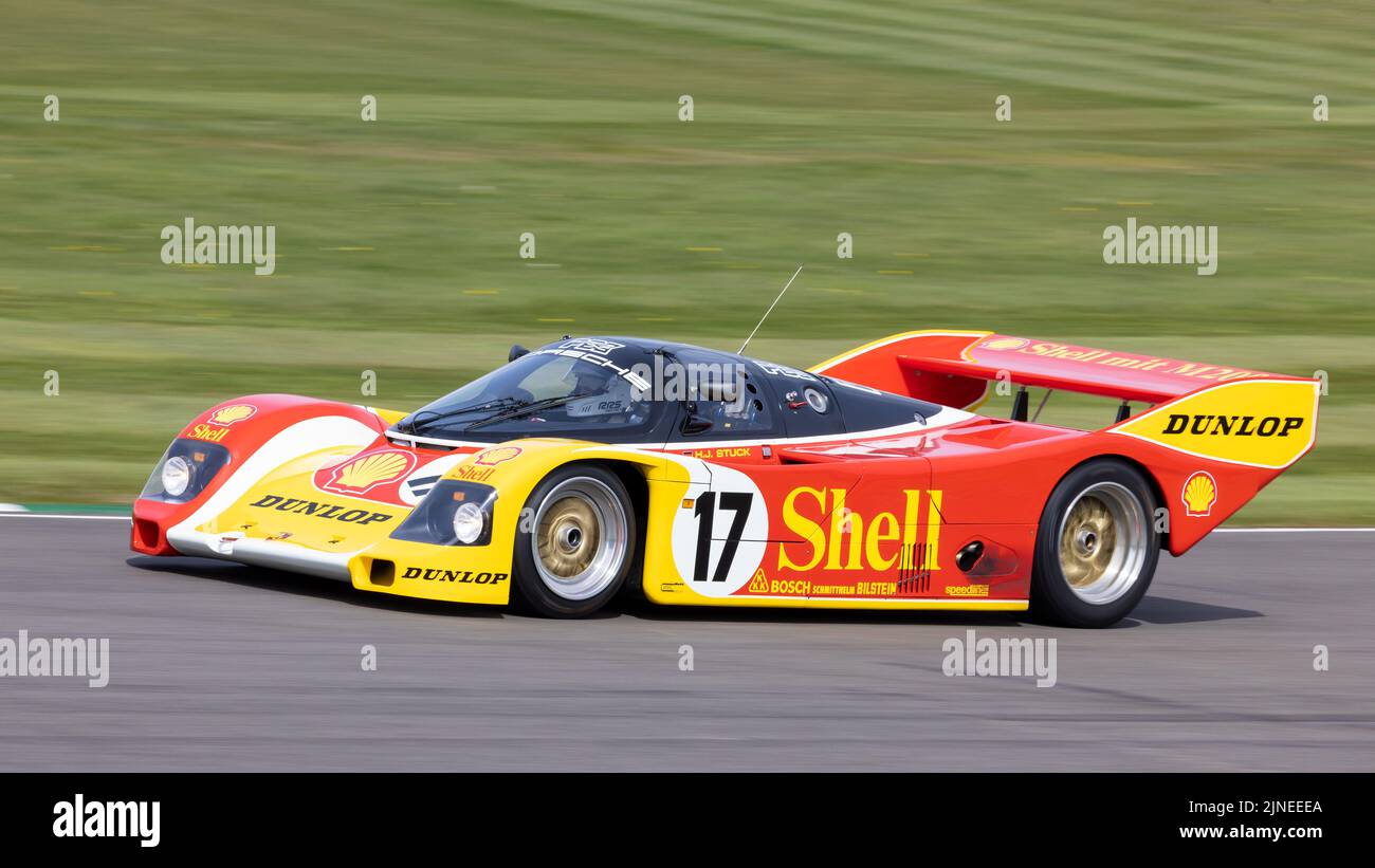 1987 Porsche 962C Le Mans racer with driver Hans-Joachim Stuck at the 79th Members Meeting, Goodwood, Sussex, UK. Stock Photo