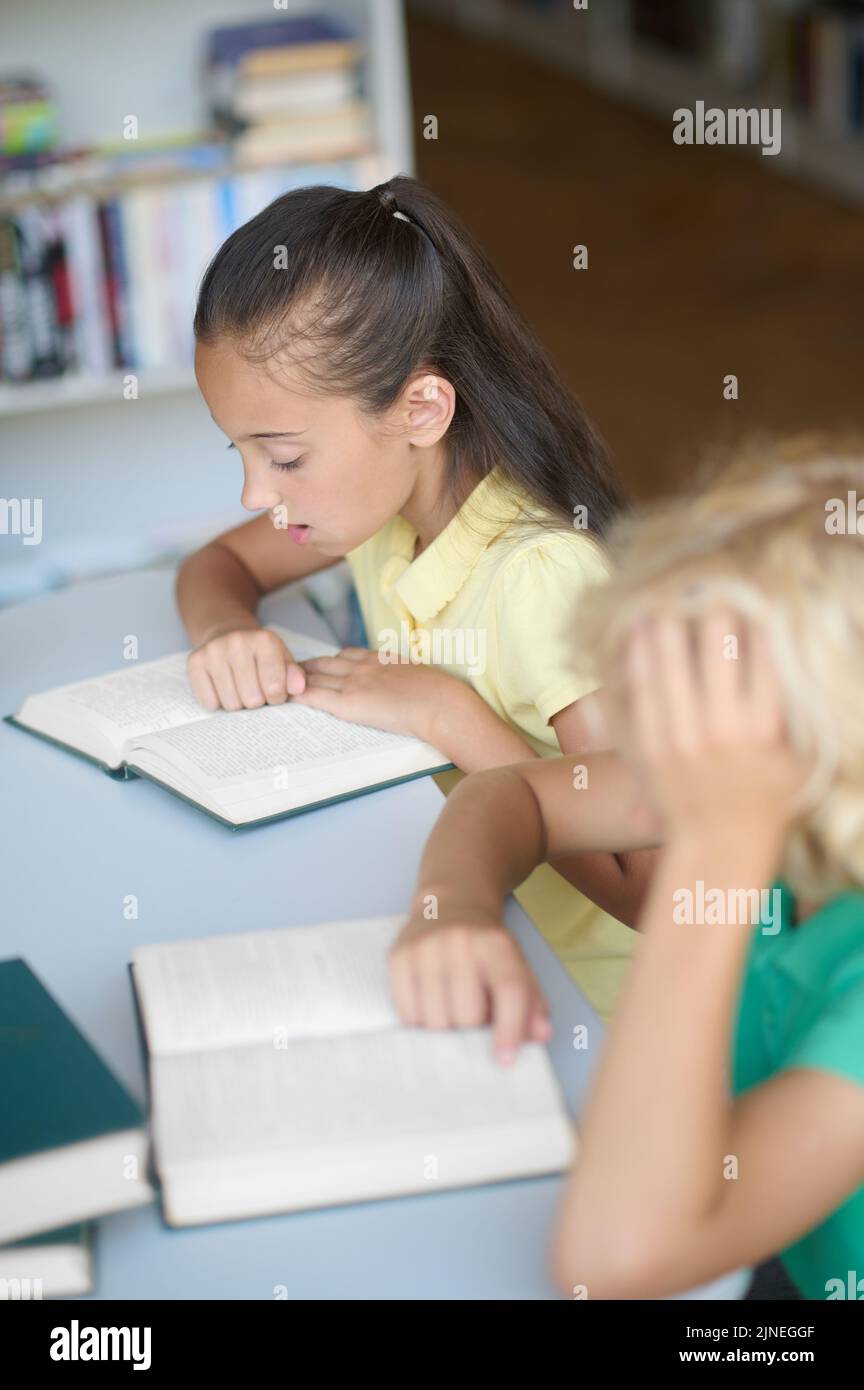 Two kids studying in the school library Stock Photo