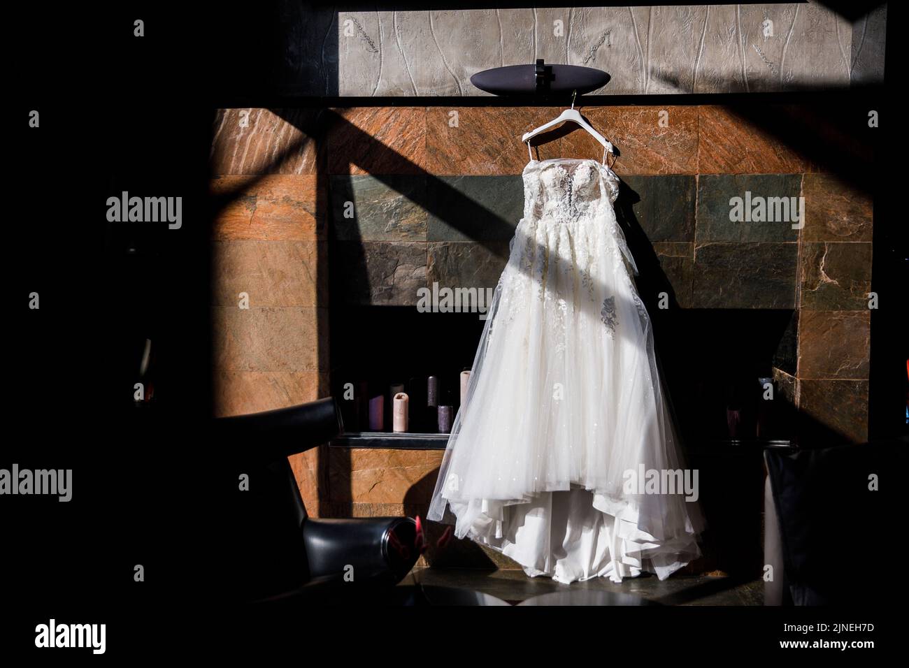 Wedding dress hanging on a stone wall Stock Photo - Alamy