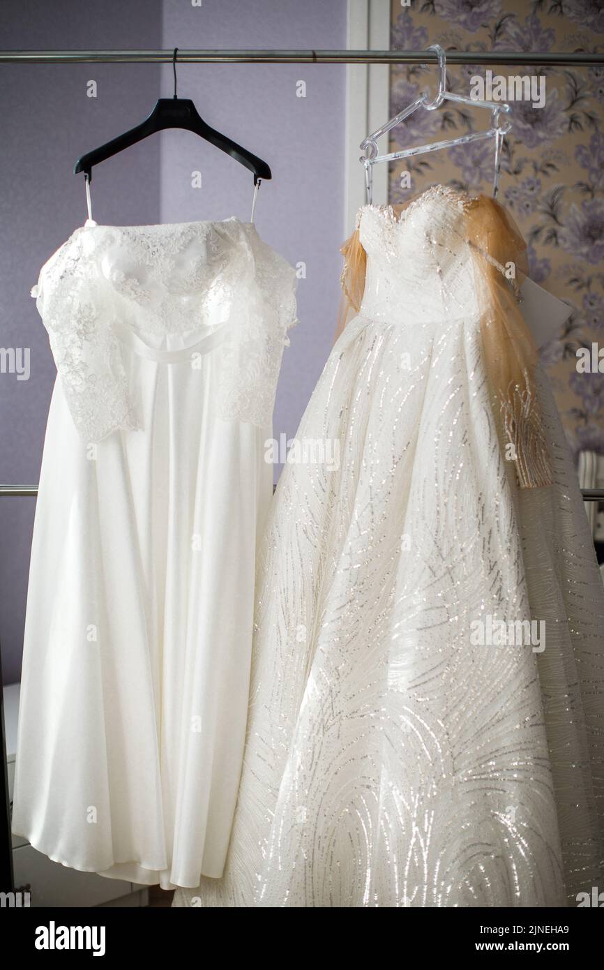 Two wedding dresses hanging on a hanger Stock Photo - Alamy