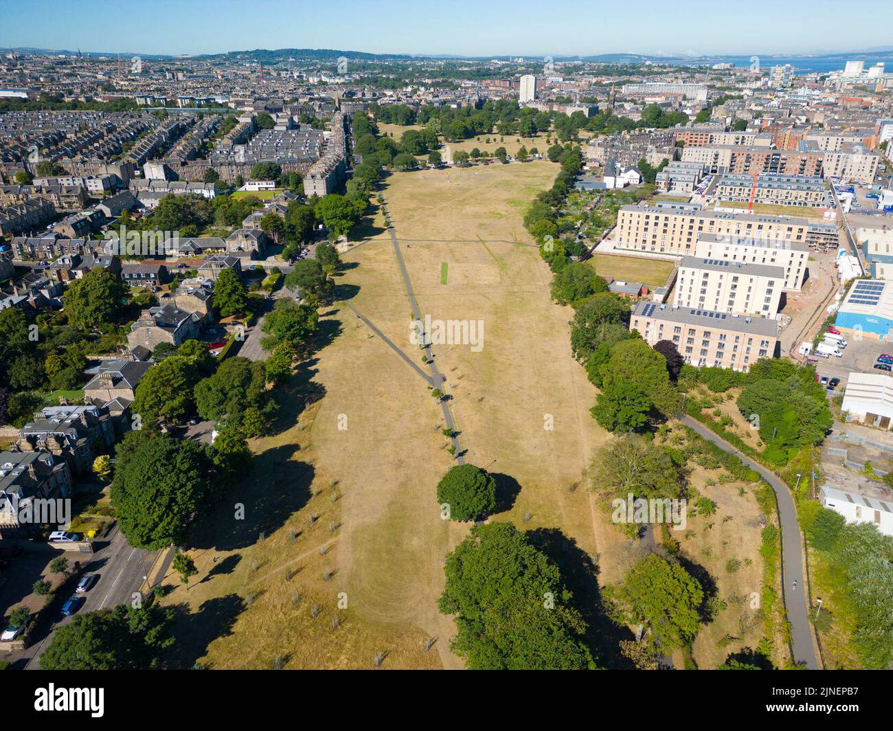Edinburgh, Scotland, UK. 11th August 2022.  Aerial view of dry burned grass in Edinburgh parks caused by prolonged summer with low rainfall. Although drought conditions are not as severe as in southern England, recent  low rainfall is causing concern in many parts of Scotland. Pic; The grass in Leith Links park is parched and yellow.  Iain Masterton/Alamy Live News Stock Photo