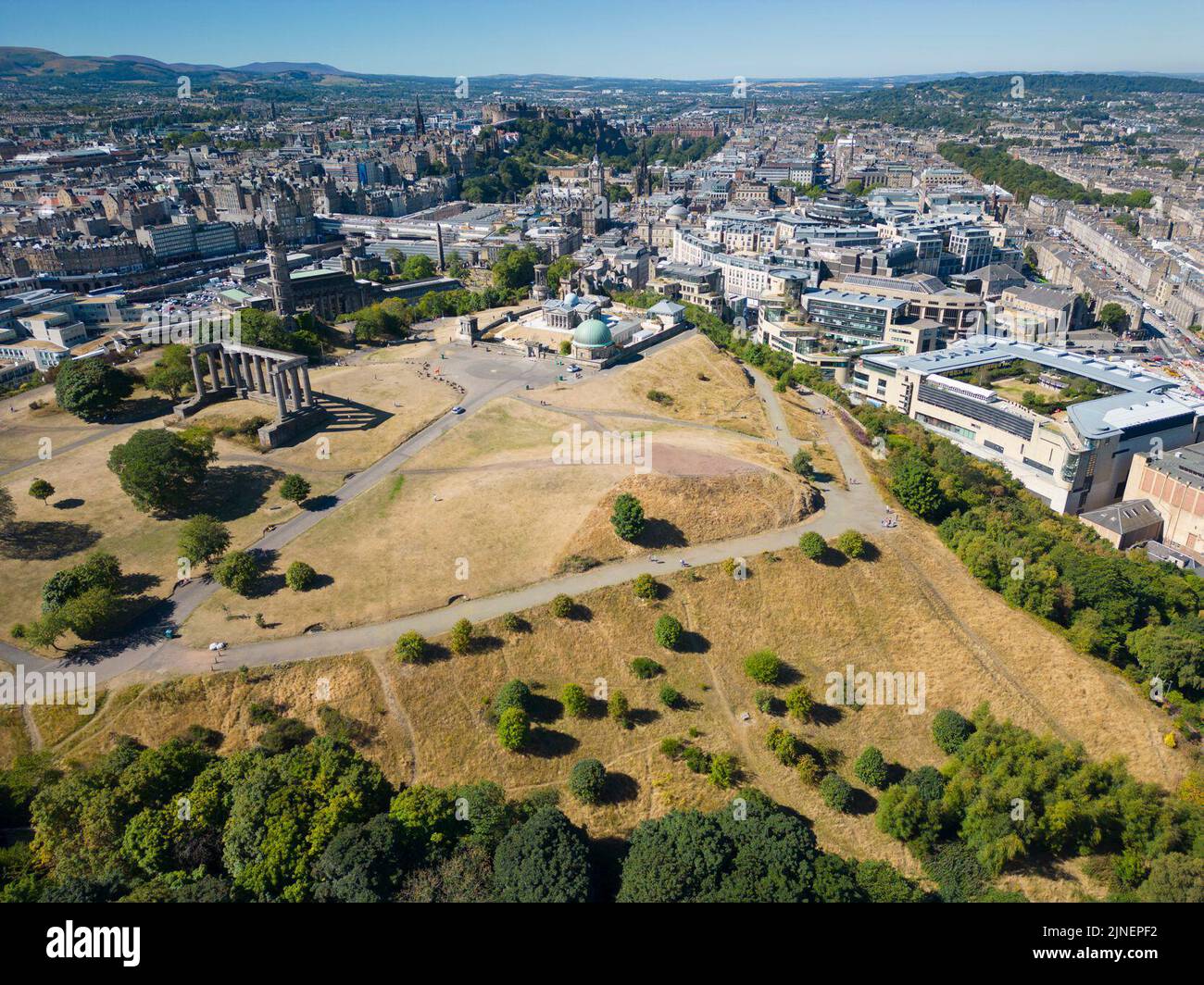 Edinburgh, Scotland, UK. 11th August 2022.  Aerial view of dry burned grass in Edinburgh parks caused by prolonged summer with low rainfall. Although drought conditions are not as severe as in southern England, recent  low rainfall is causing concern in many parts of Scotland. Pic; Parched and yellowed grass on Calton Hill .  Iain Masterton/Alamy Live News Stock Photo
