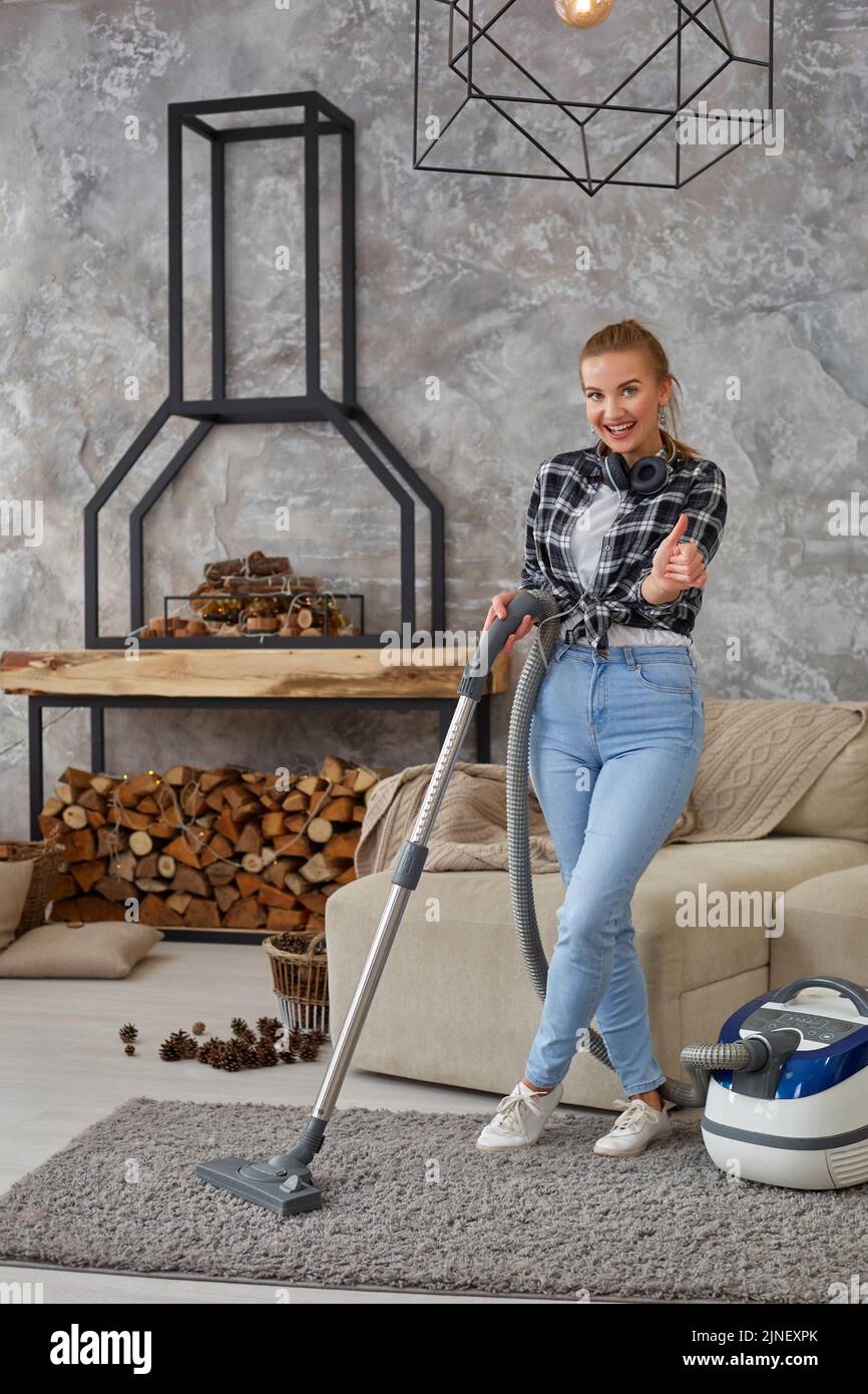 Slim woman cleaning with vacuum cleaner carpet Stock Photo - Alamy