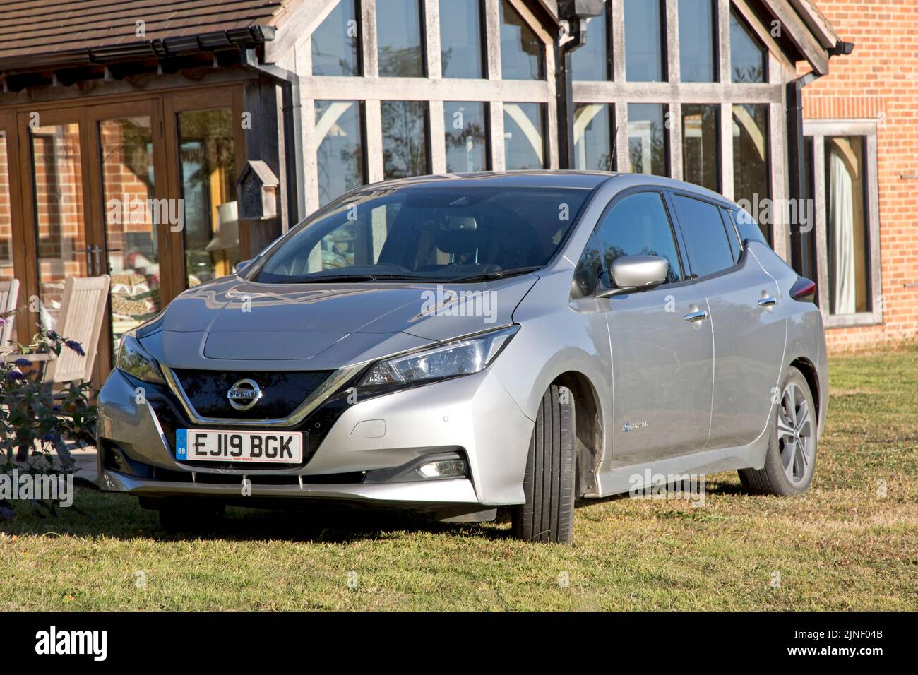 Metallic grey Nissan Leaf e-connecta EV electric car parked outside ecohouse Cotswolds UK Stock Photo