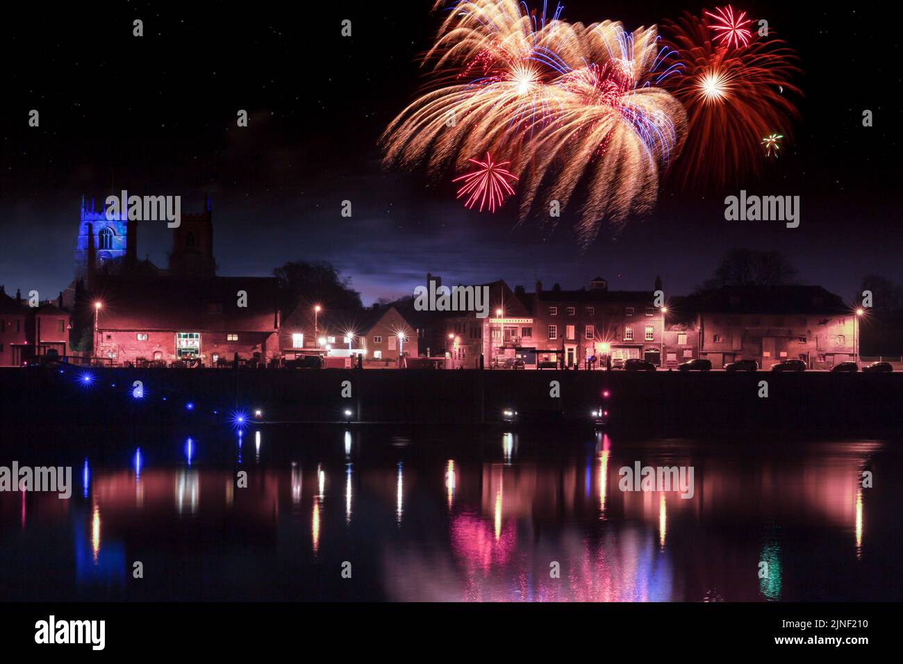 Fireworks at Kings Lynn in Norfolk UK 2018. Rockets exploding in a display over the Great River Ouse at night time. Historic town at night with reflec Stock Photo