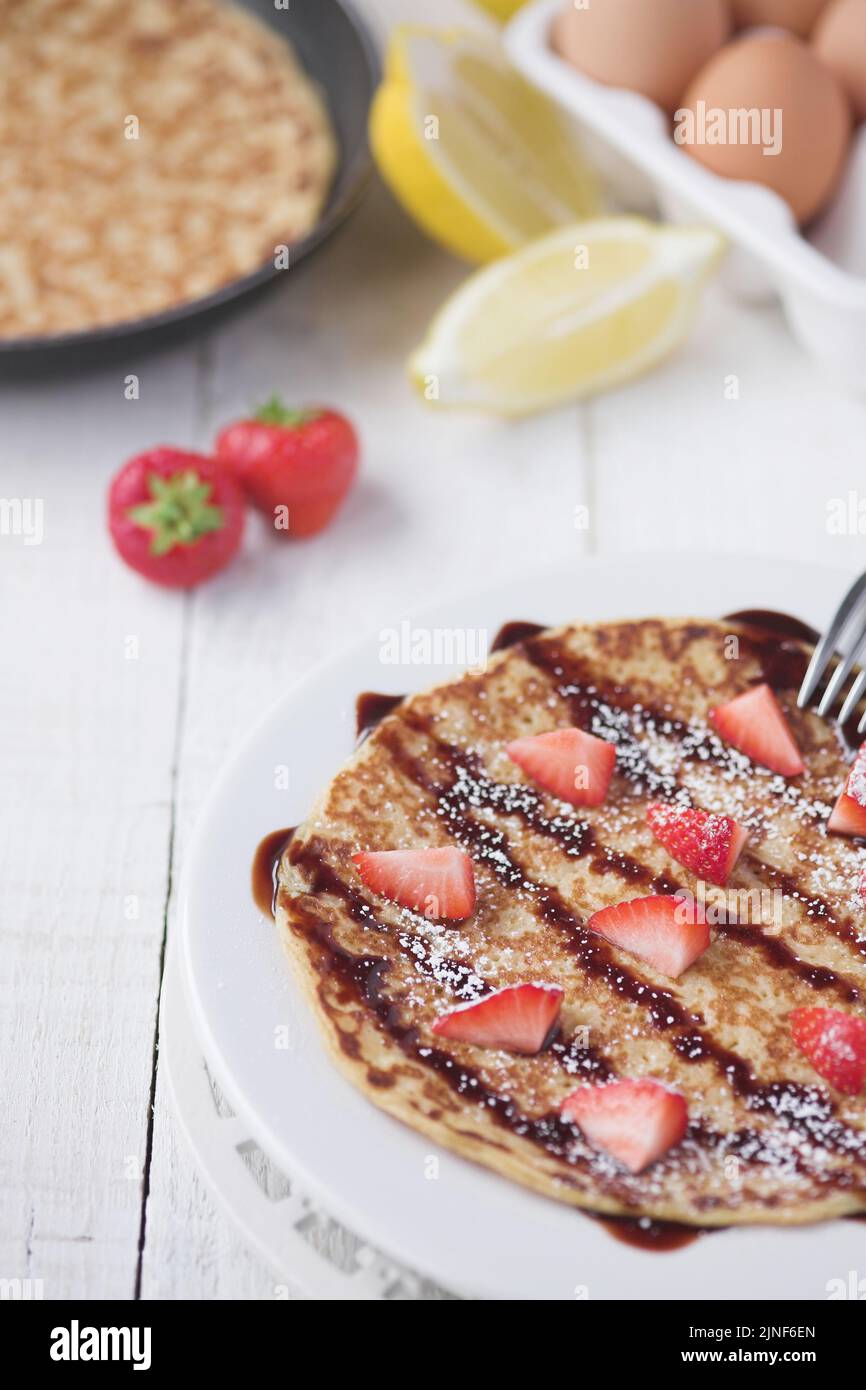 Freshly prepared crepes with strawberries - shallow dof Stock Photo