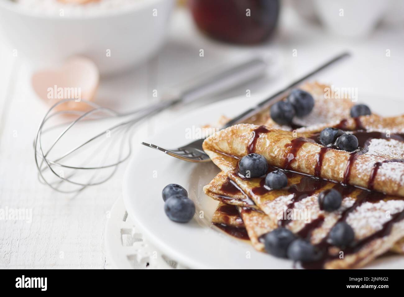 Freshly prepared crepes with blueberries & chocolate sauce - shallow dof Stock Photo
