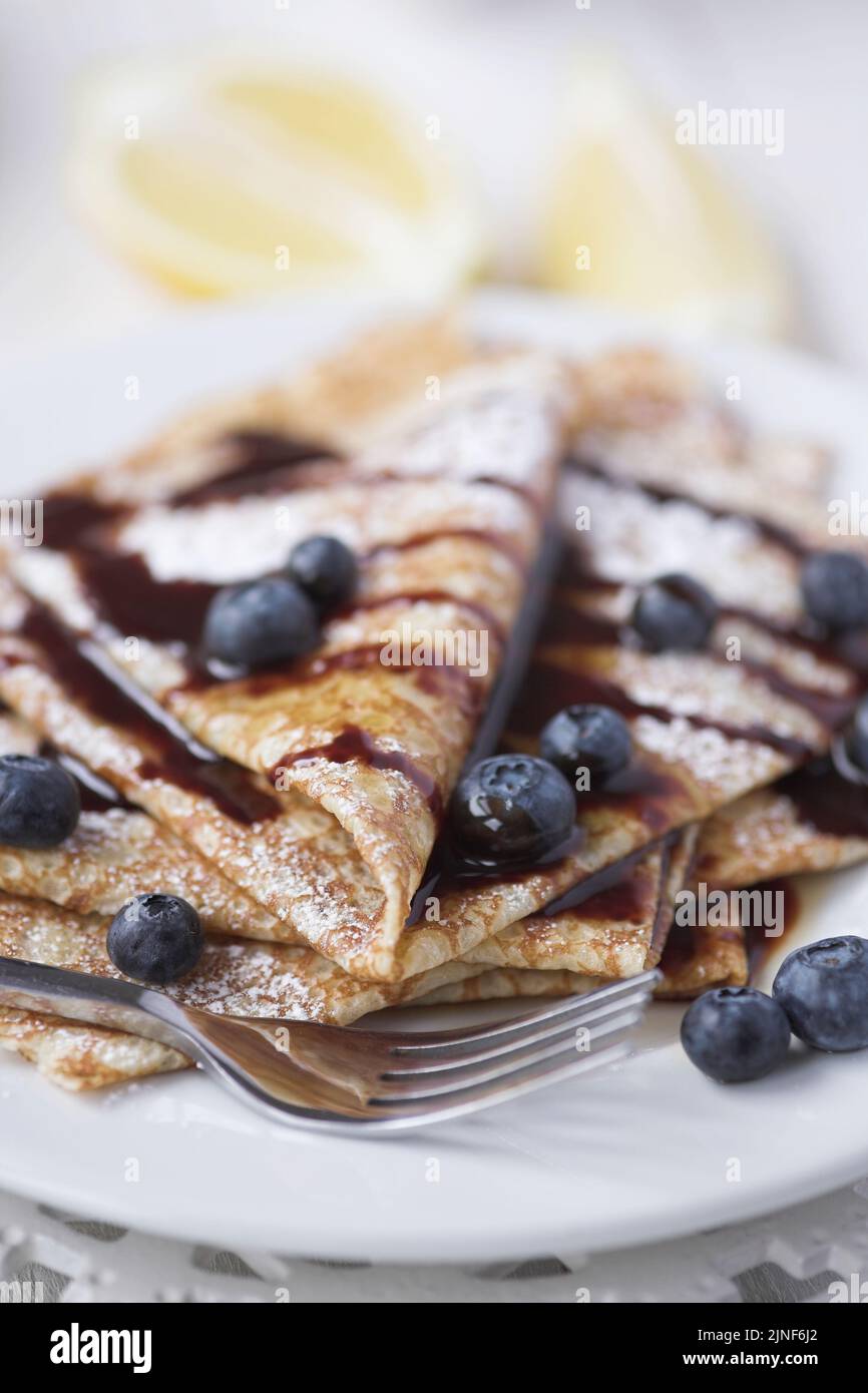 Freshly prepared crepes with blueberries & chocolate sauce - shallow dof Stock Photo