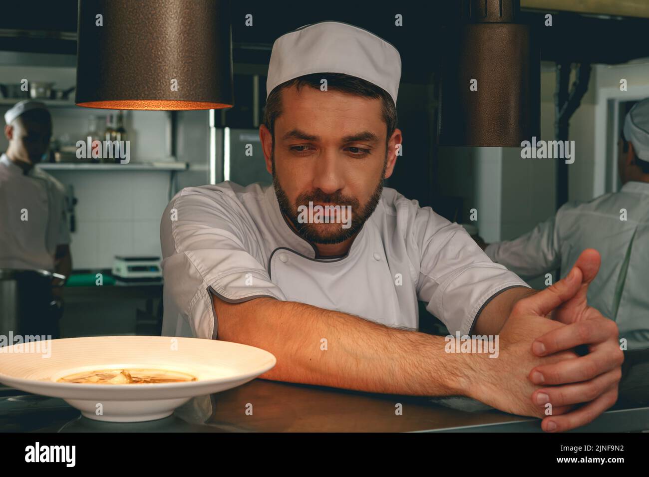 Tired chef on kitchen restaurant waiting for a new order and looking on