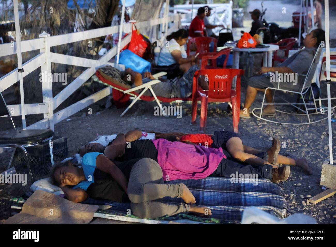 Relatives of miners sleep as they wait for news about their loved ones outside the facilities of a coal mine where a mine shaft collapsed leaving miners trapped, in Sabinas, Coahuila state, Mexico, August 11, 2022. REUTERS/Luis Cortes Stock Photo