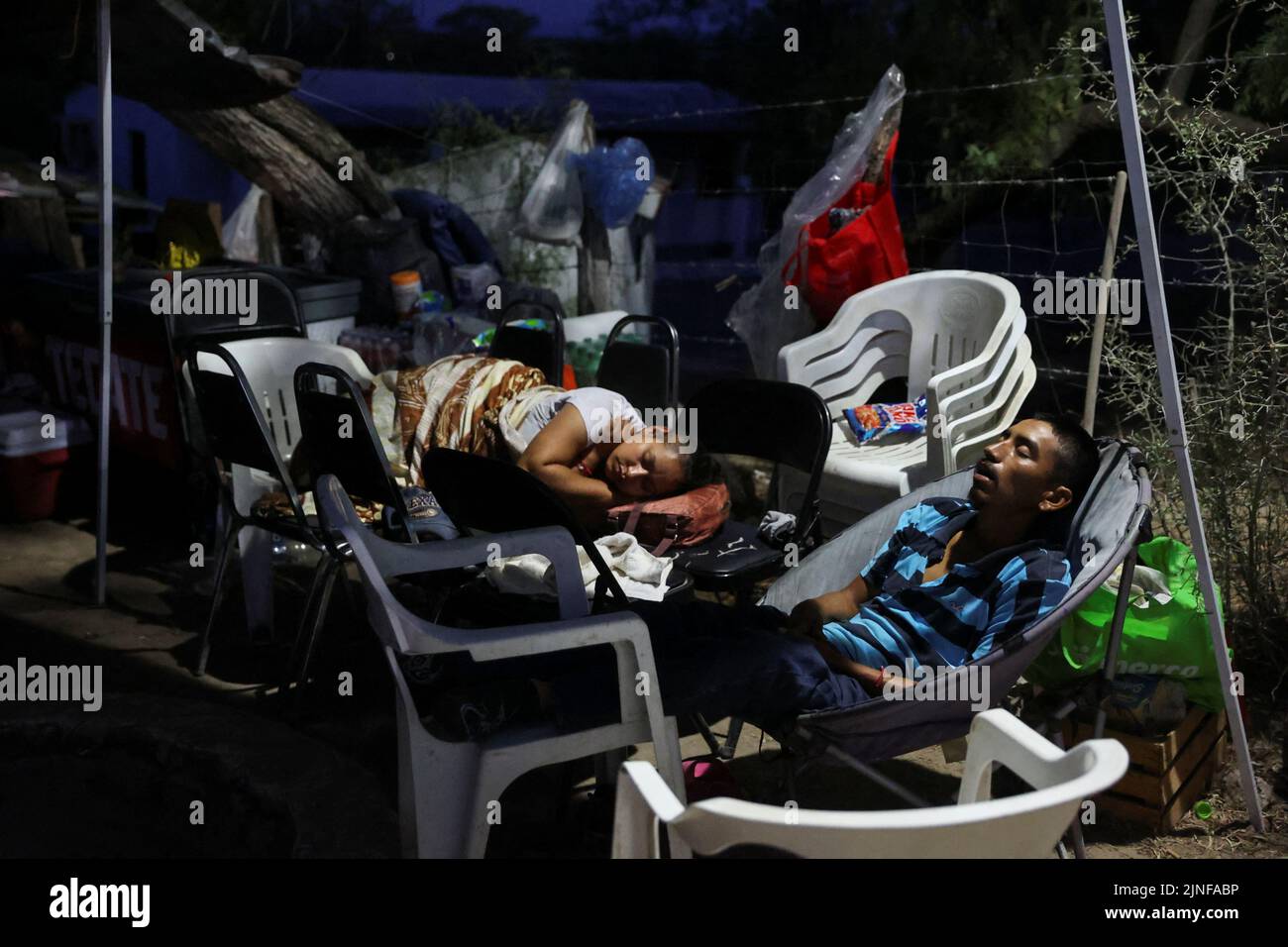 Relatives of miners sleep as they wait for news about their loved ones outside the facilities of a coal mine where a mine shaft collapsed leaving miners trapped, in Sabinas, Coahuila state, Mexico, August 11, 2022. REUTERS/Luis Cortes Stock Photo