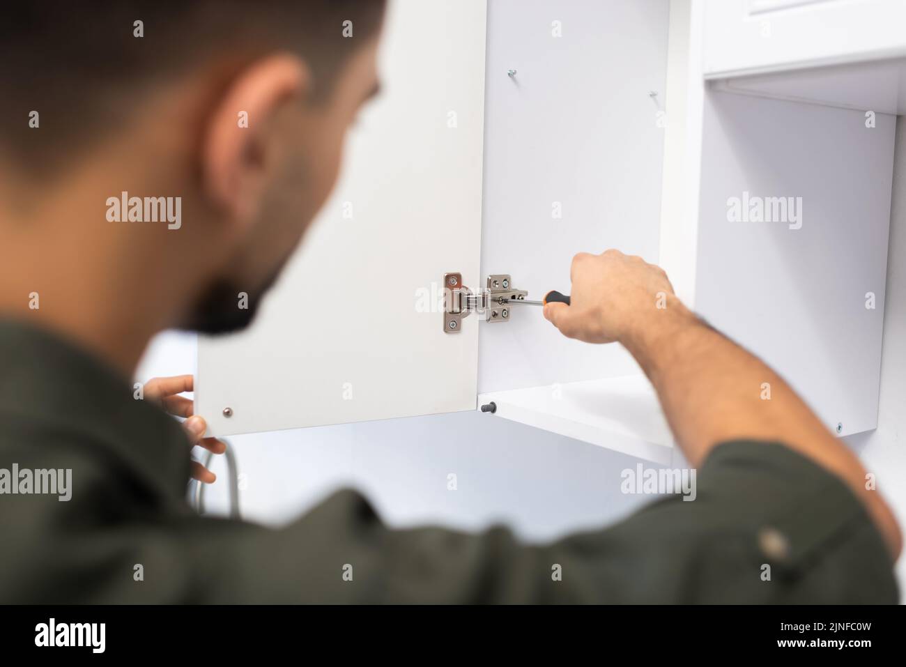 Blurred man fixing kitchen cabinet at home,stock image Stock Photo