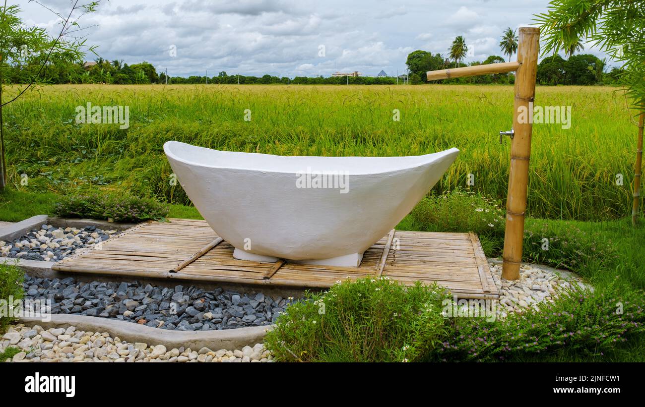 white bathtub outside looking out over a green rice field, bath tub