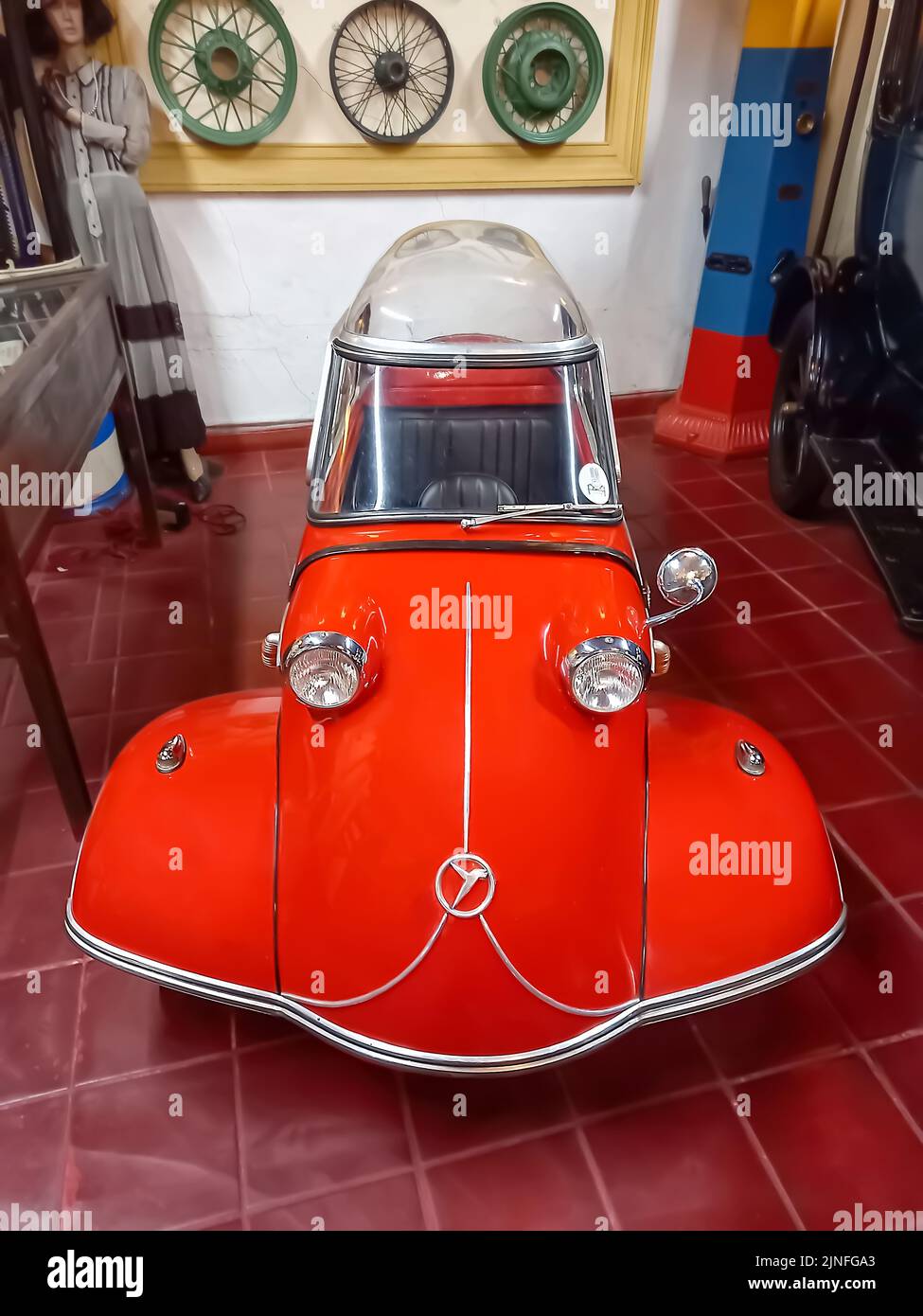 Old classic red economy Messerschmitt KR200 Kabinenroller 1959 coupe one door three wheel German micro car. Automobile Museum. Front view. High angle Stock Photo