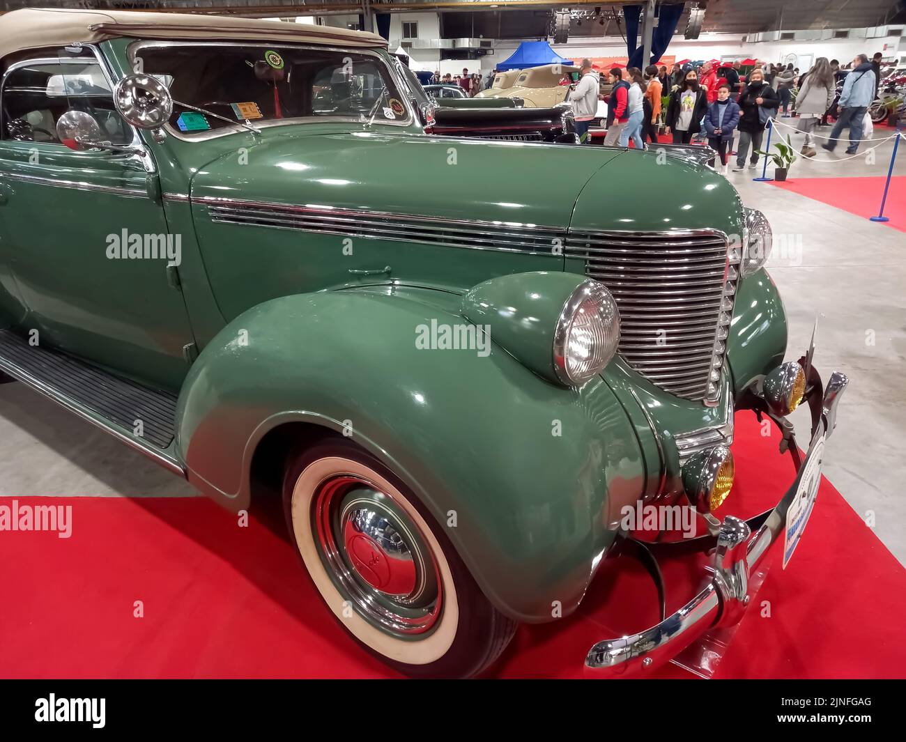 Old antique green 1938 DeSoto Six series S-5 coupe convertible on a red carpet. Chromes. Grille. Exhibit hall. Classic car show. Stock Photo