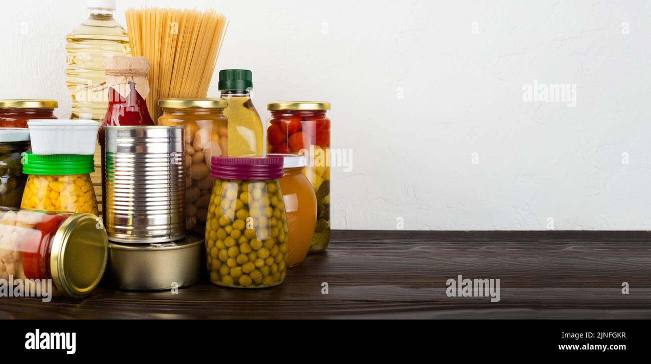 Emergency survival food set on dark wooden kitchen table Stock Photo