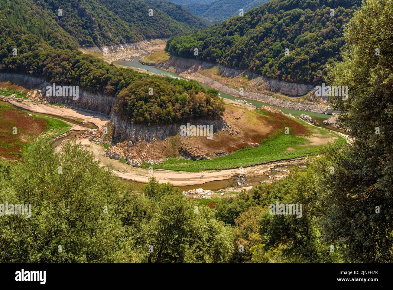 Dry tail meander of the Susqueda reservoir during the summer drought of 2022 (La Selva, Girona, Catalonia, Spain) ESP: Meandro del embalse de Susqueda Stock Photo