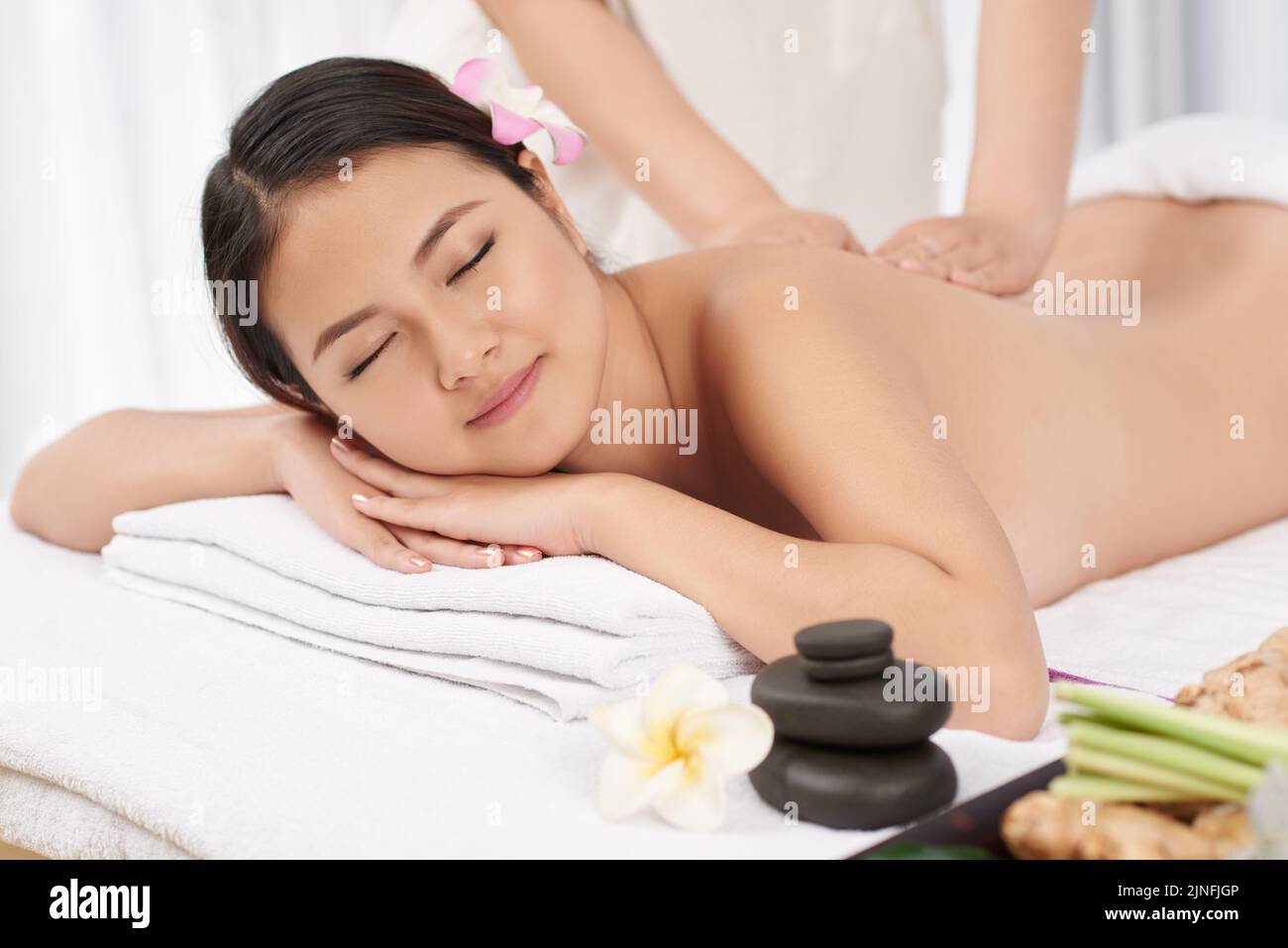 Young Asian woman smiling when getting back massage Stock Photo