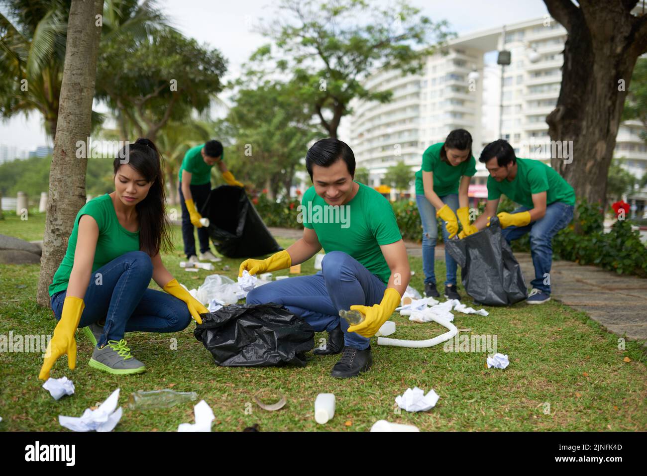 Young people picking up garbage in local park Stock Photo