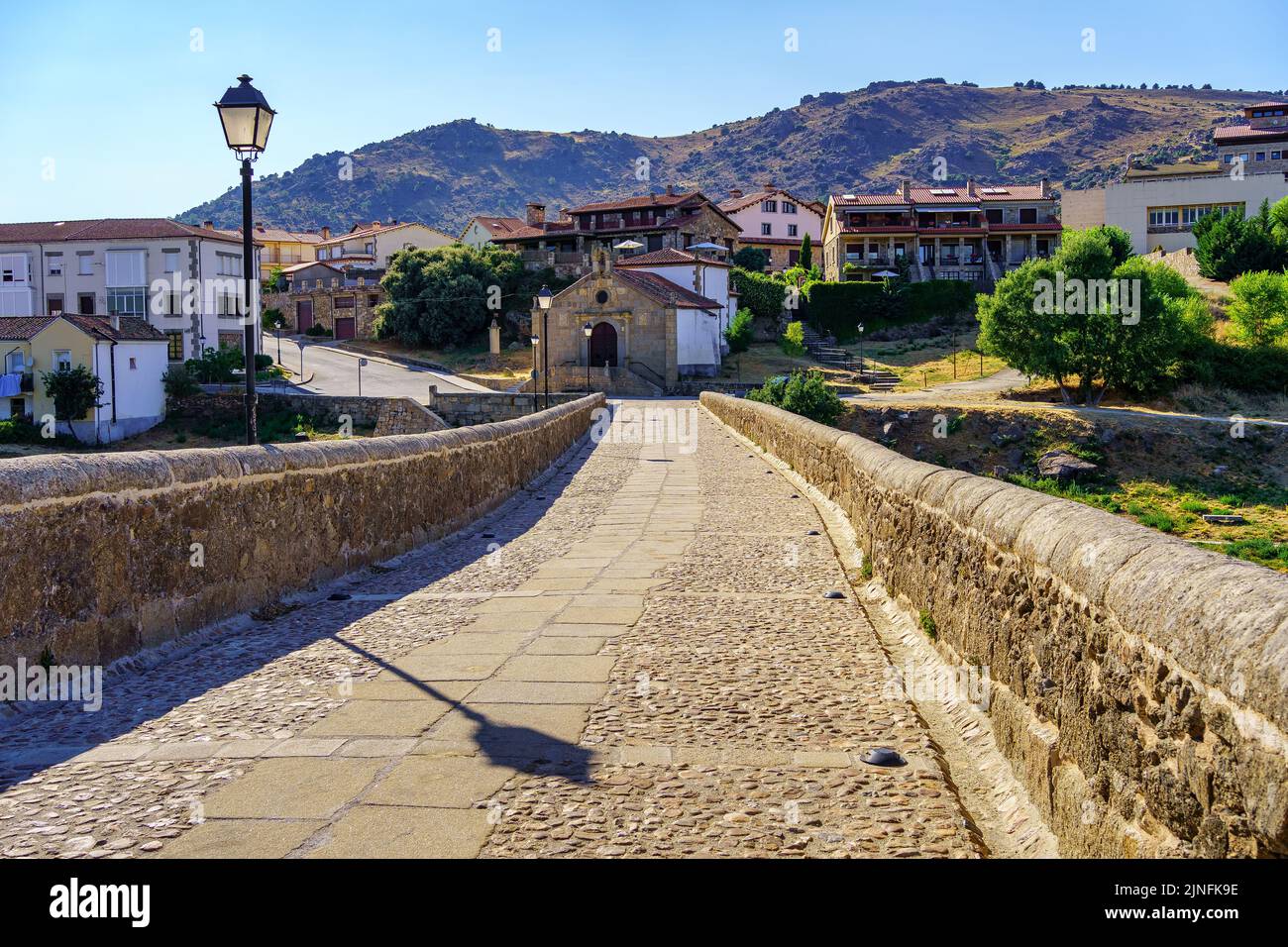 Stone path over a medieval Romanesque bridge to the old houses of the Barco de Avila, Spain. Stock Photo